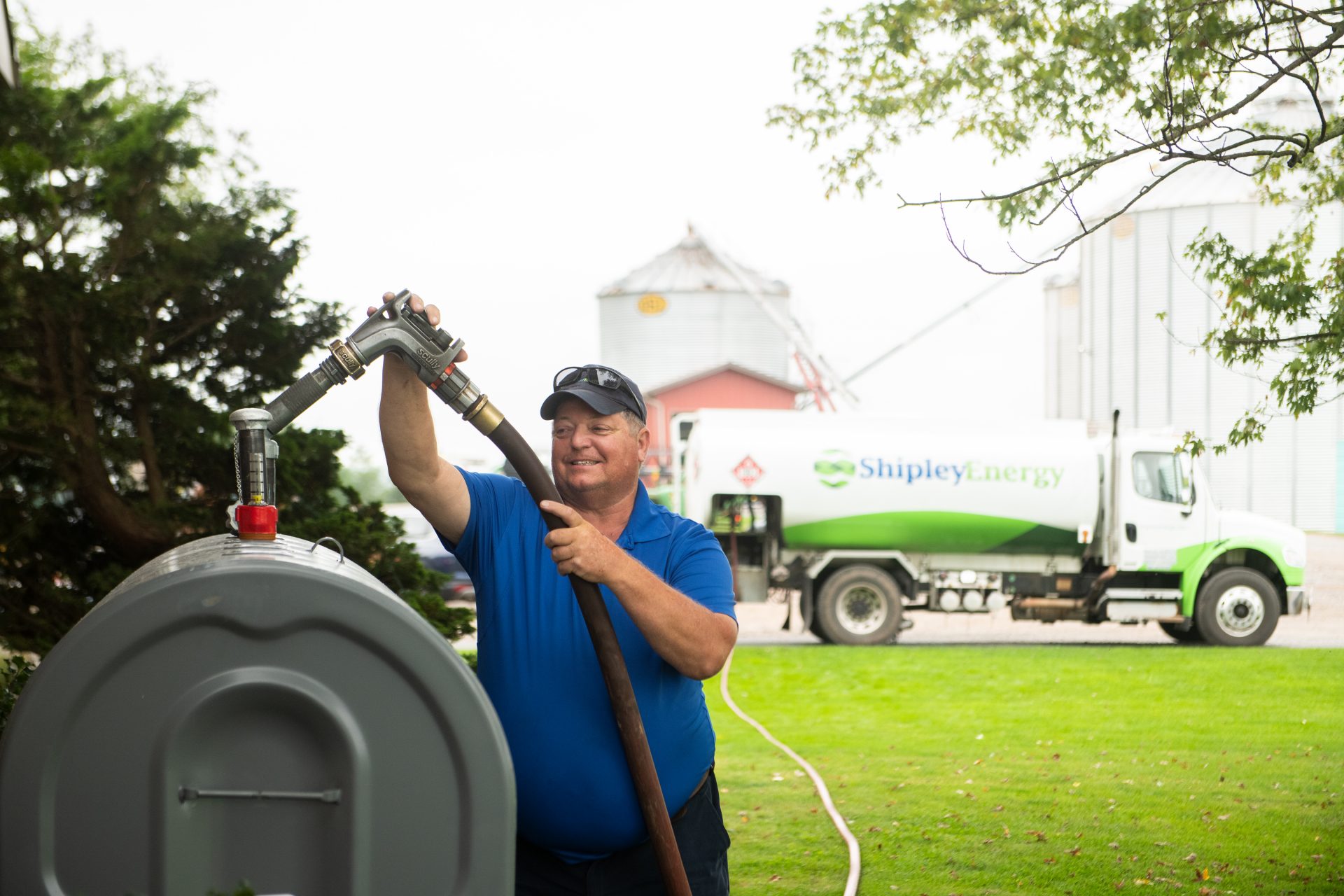 Shipley Energy heating oil delivery man smiling while filling a customer's tank.